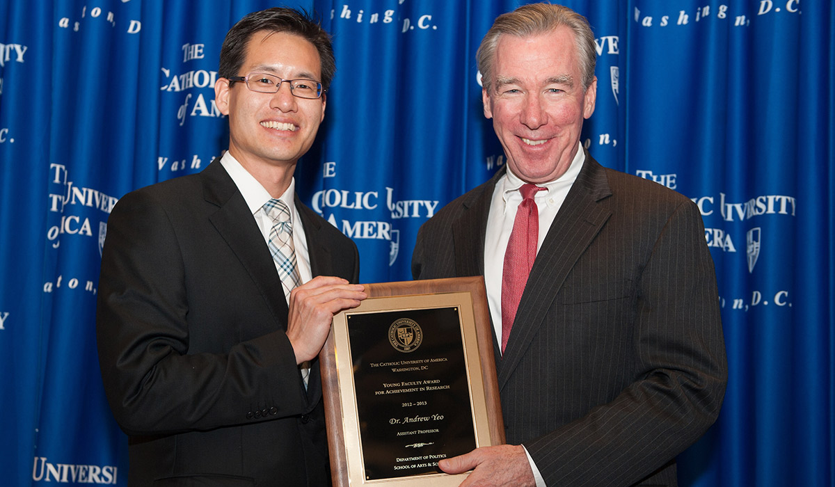 Dr. Andrew Yeo being given an award by University President John Garvey